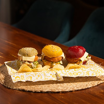 Three colourful sliders served on a tray at Xero Degrees